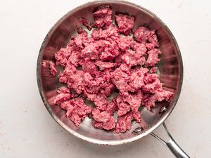 Ground beef in a skillet to be browned for a baked ziti recipe.