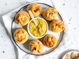 Potato Knishes on a Plate with a Bowl of Mustard